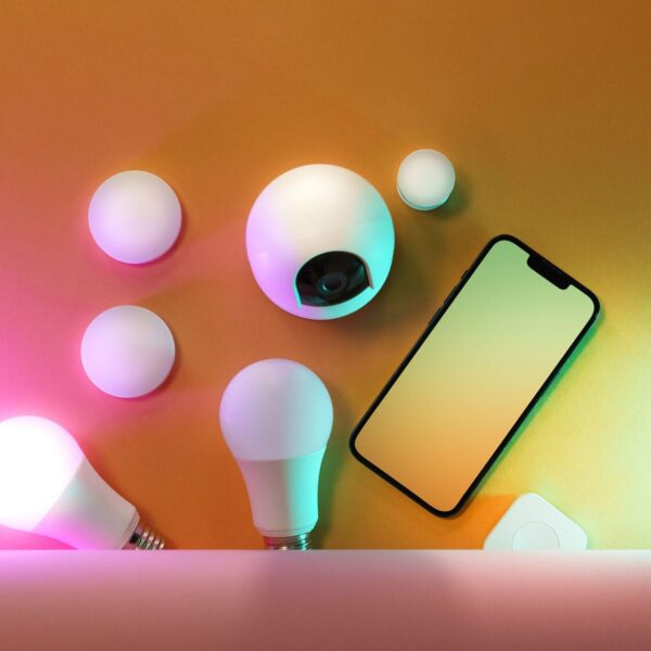 A collection of smart home devices including light bulbs and a smartphone, showcasing modern technology.