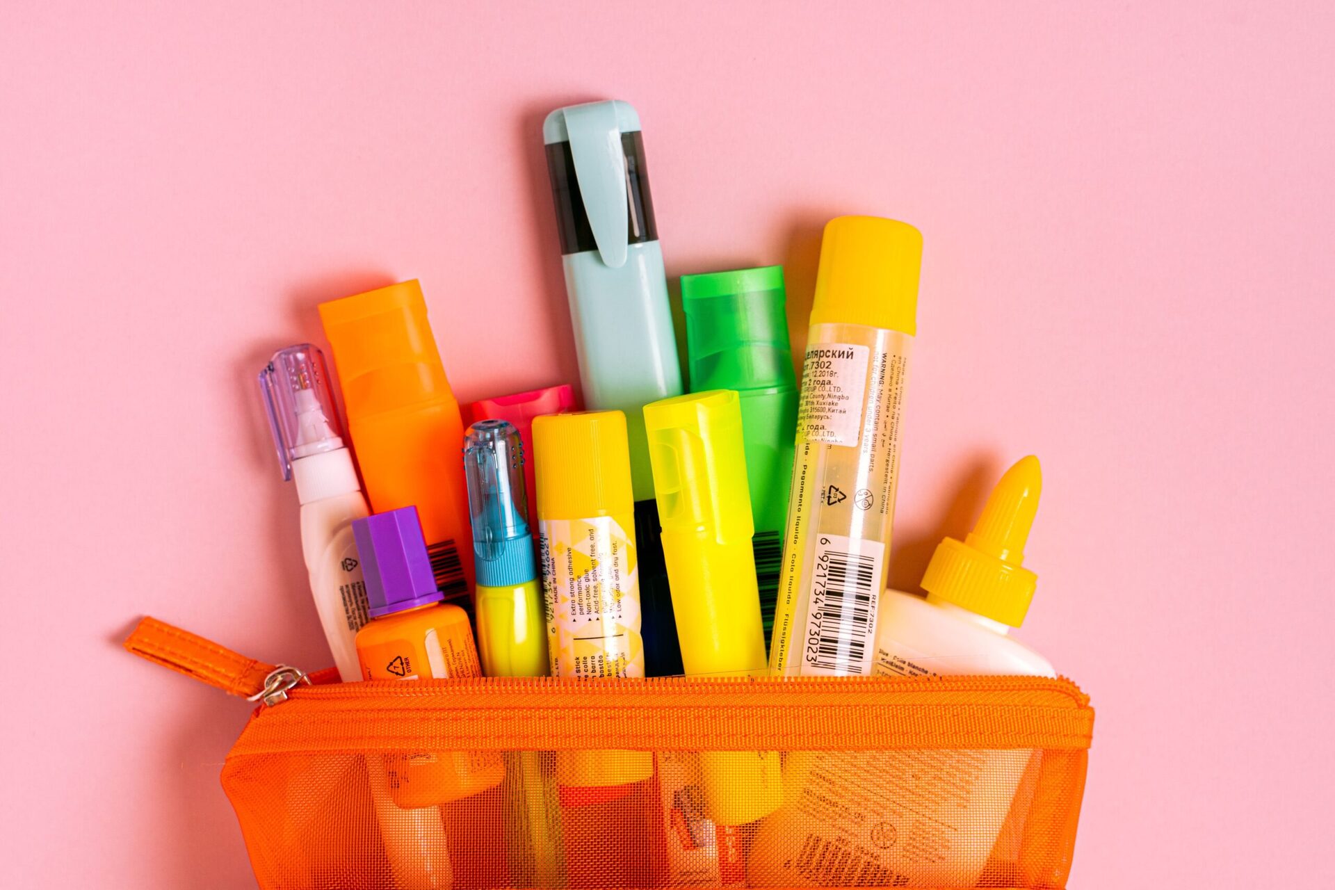 Bulk Silicone Fittings 1 Bright office essentials in a mesh pouch on a pink background. Perfect for stationery enthusiasts.
