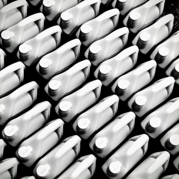 Patterned arrangement of plastic bottles viewed from above in black and white.
